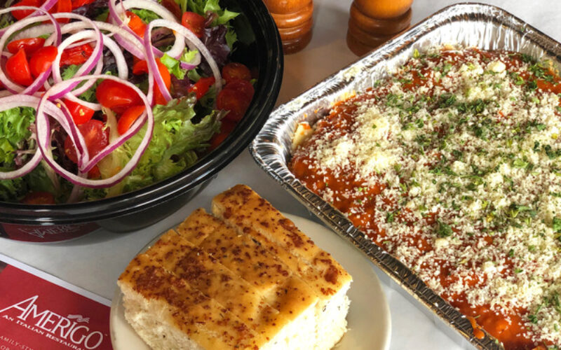 salad, lasagna, and bread on a table next to an Amerigo menu and salt and pepper grinders